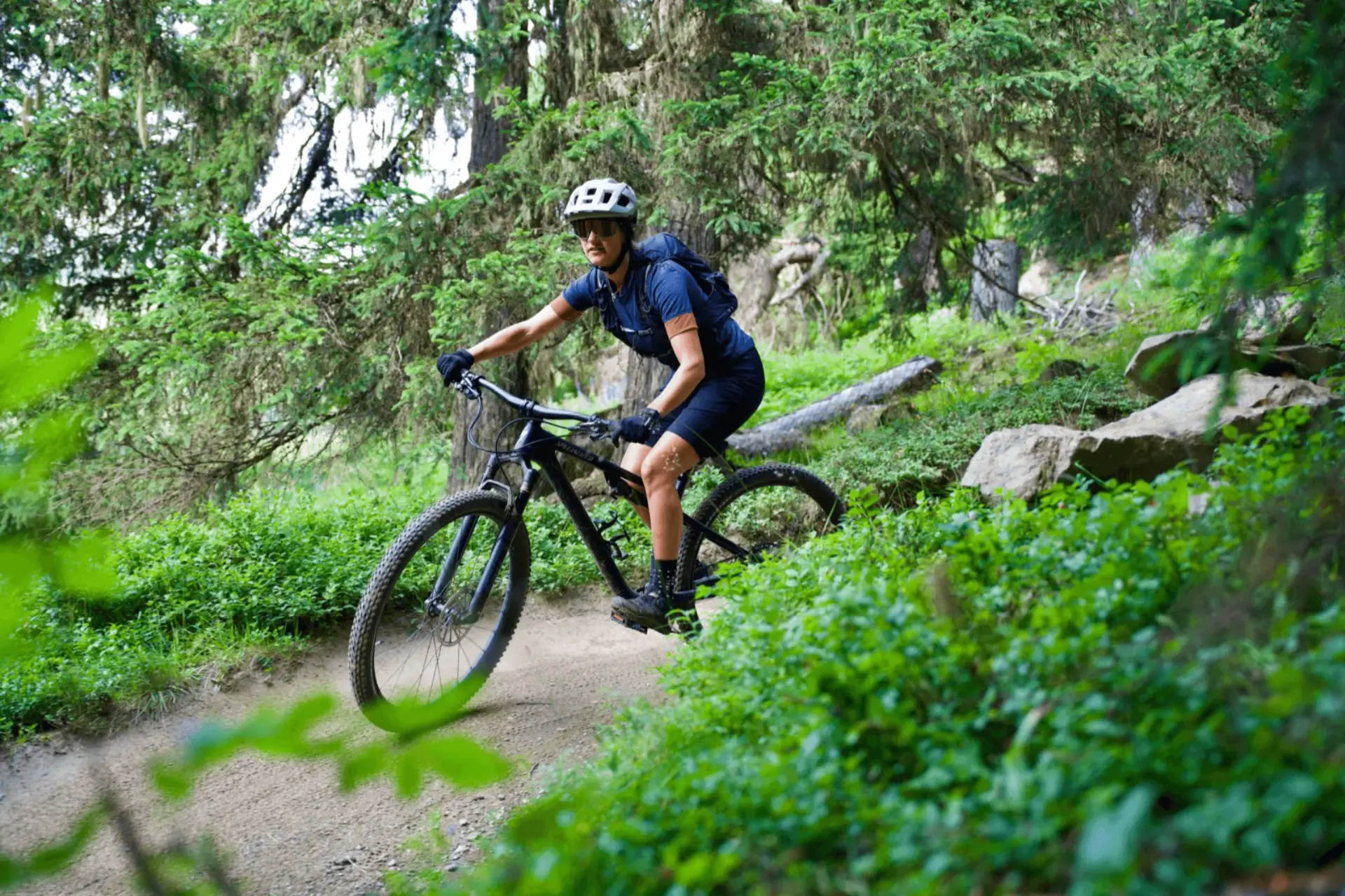 Rider en VTT sur un singletrack en forêt près de Verbier